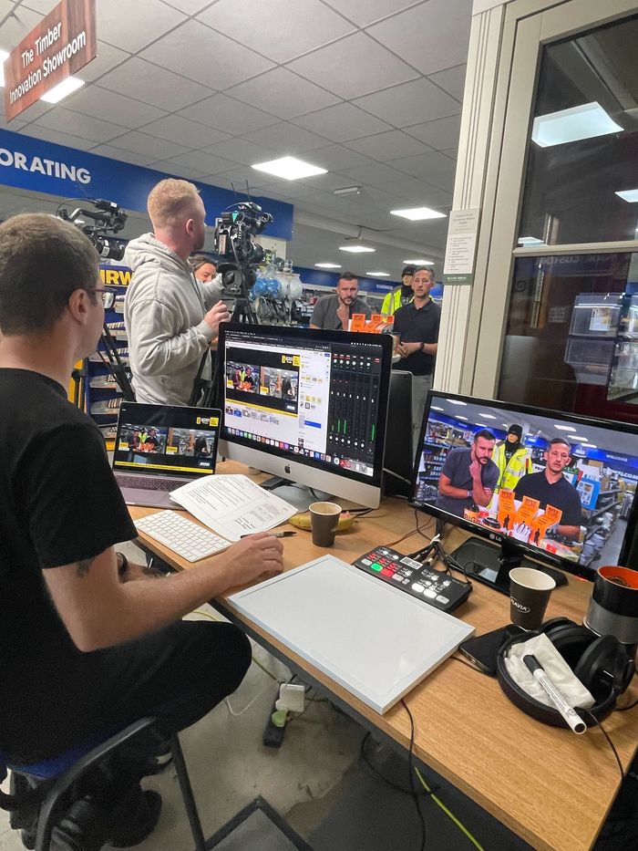Live audio/video control booth with staff monitoring multiple screens at an event