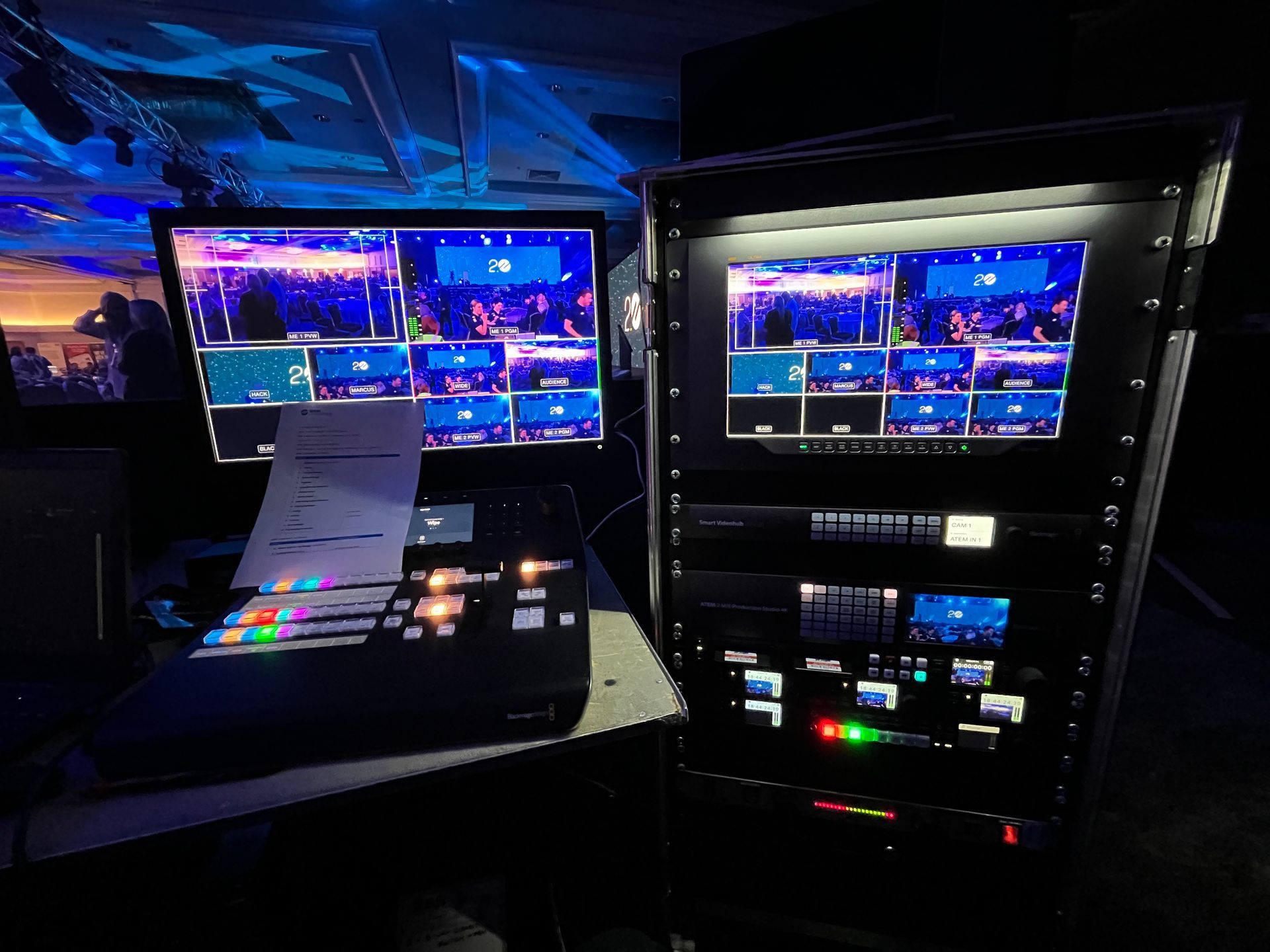 Video production control room with monitors and equipment; blue lighting.
