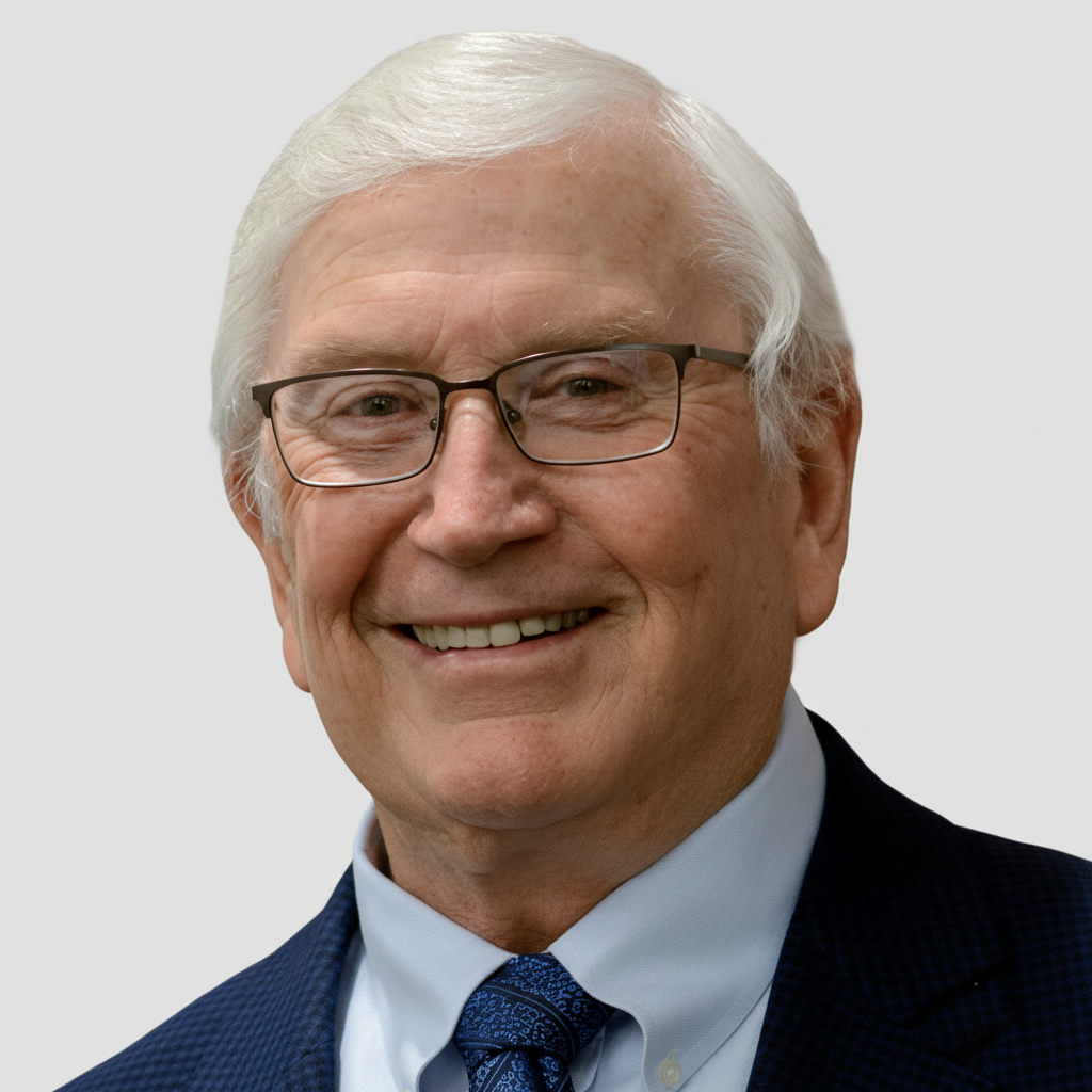 Smiling man in glasses and a blue suit against a light gray background