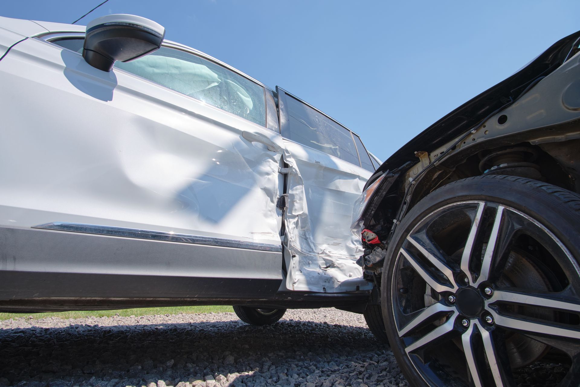 A white car has been damaged in a car accident.