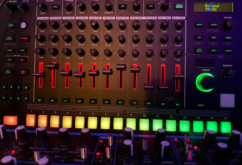 Close-up of a colorful audio mixer with glowing red, green, and orange controls