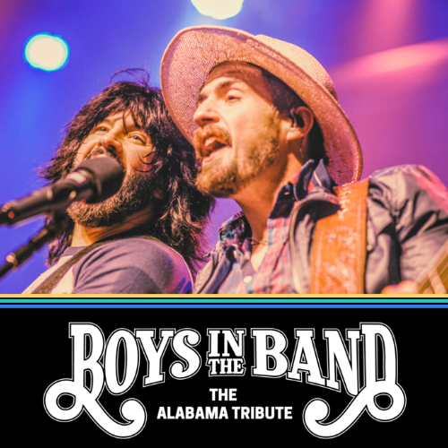 Two singers performing under stage lights above a โBoys in the Bandโ tribute banner