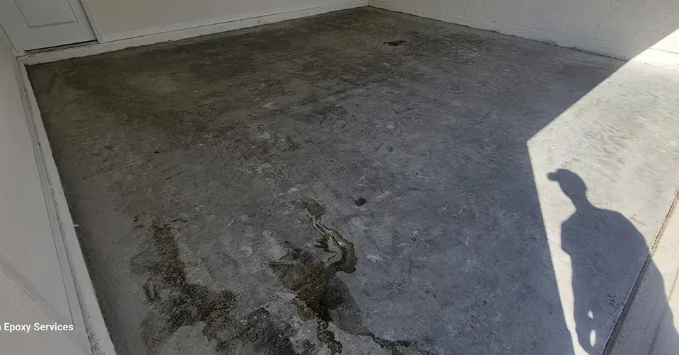 Concrete surface with wet patches, shadow of a person.