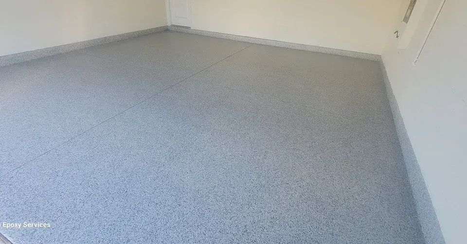 Gray speckled epoxy floor in a room with white walls and a gray trim.