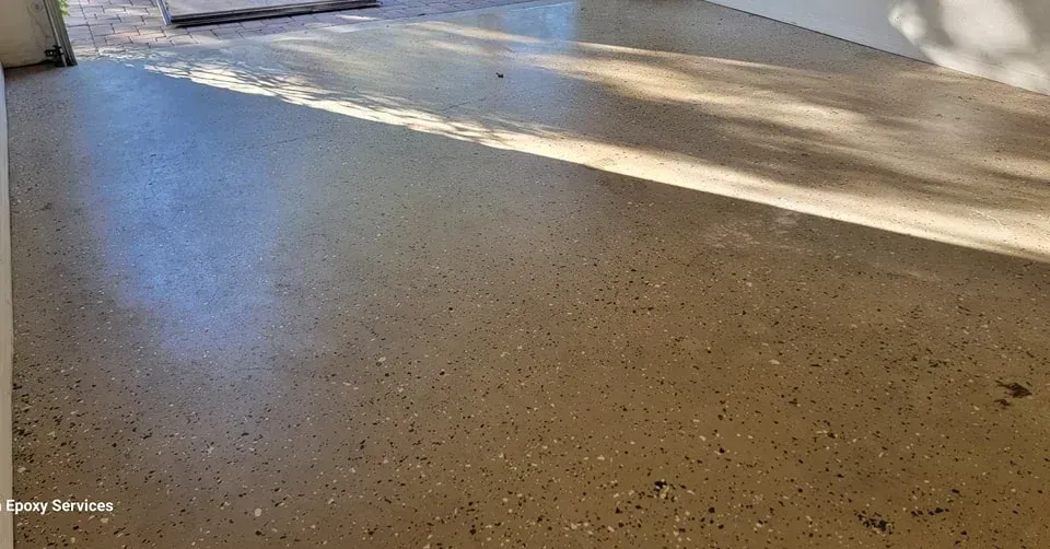 Epoxy-coated garage floor with sunlight and shadows cast across it.