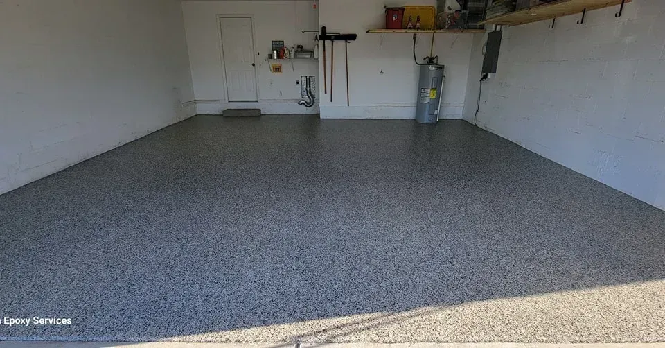 Garage with gray epoxy floor, white walls, and a water heater.