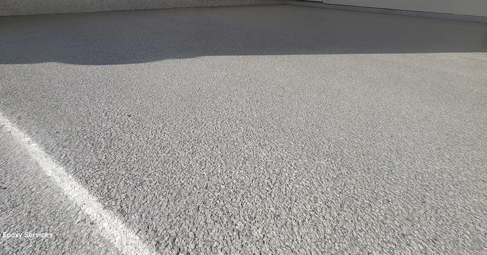 Gray textured surface with a white painted line and shadow.