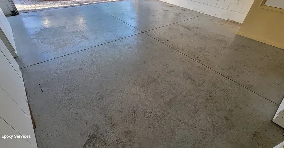Gray concrete floor with dark lines dividing sections, in a garage or similar room.