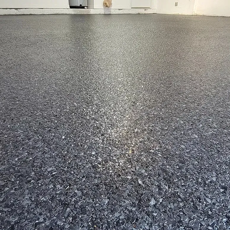Gray epoxy floor with speckled chips reflecting light.
