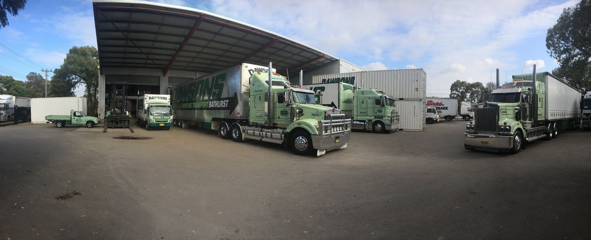 Several Green Semi-trucks Parked in a Loading Area — Dawson's Removals In Dubbo, NSW