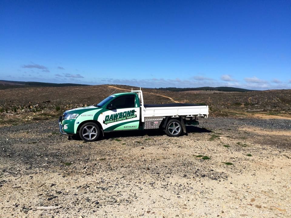 Green and White Pickup Truck on a Dirt Road With a Clear Blue Sky — Dawson's Removals In Wetherill Park, NSW