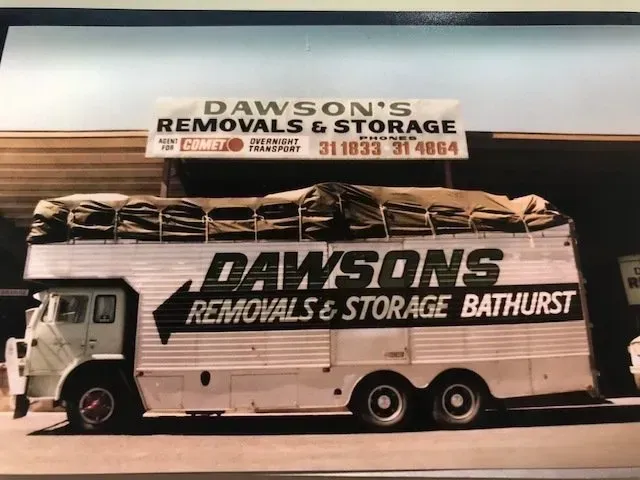 Green Semi-truck With Trailer Parked on a Dirt Road Near a Tree at Dusk — Dawson's Removals In Kelso, NSW