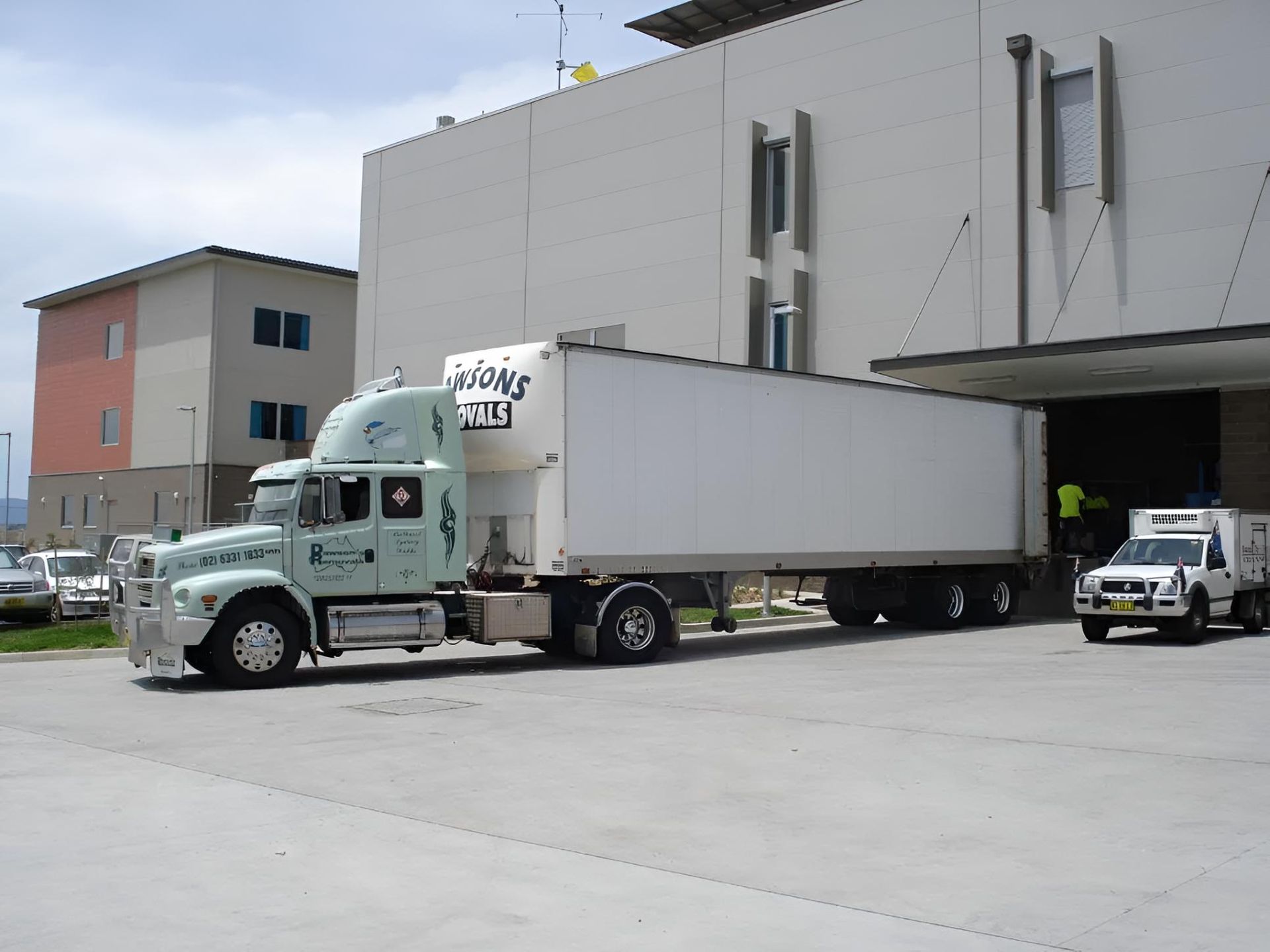 Green and White Dawson's Semi-truck Parked in front of a hospital — Dawson's Removals In Kelso, NSW