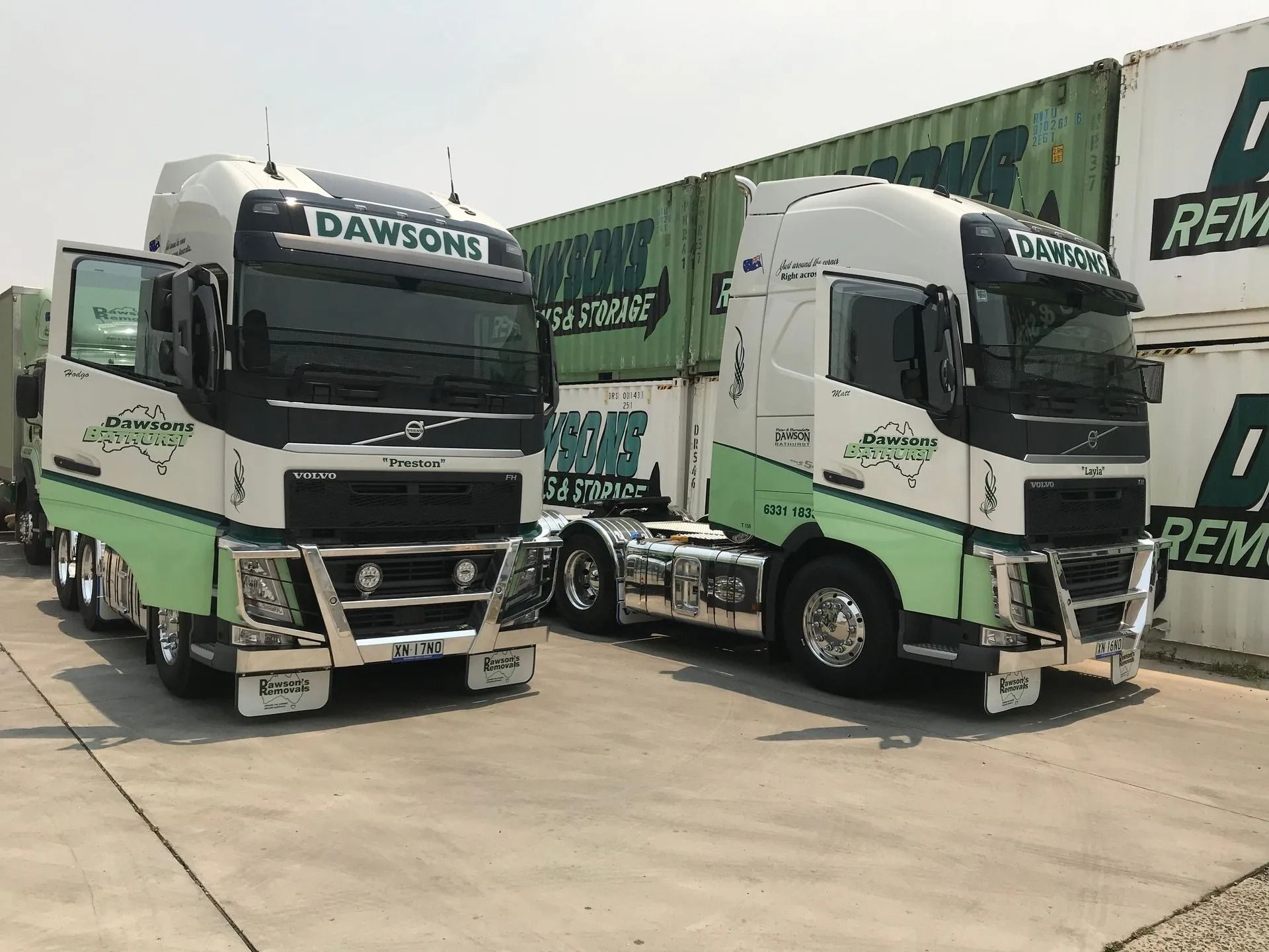 Two White and Green Semi-trucks Parked Beside Green Shipping Containers — Dawson's Removals In Wetherill Park, NSW