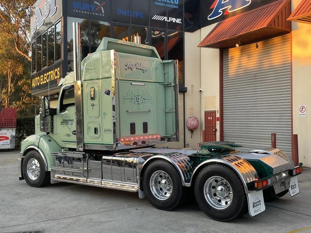 Green Semi-truck Parked Outside a Building — Dawson's Removals In Dubbo, NSW