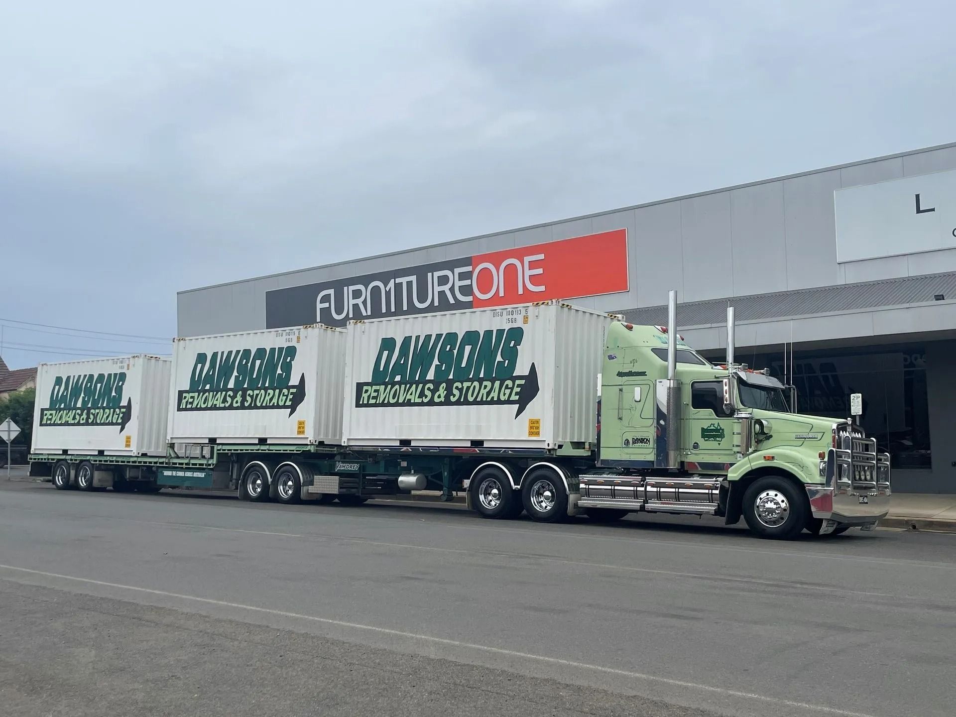 A large removal truck is parked infront of a furniture store — Dawson's Removals In Wetherill Park, NSW
