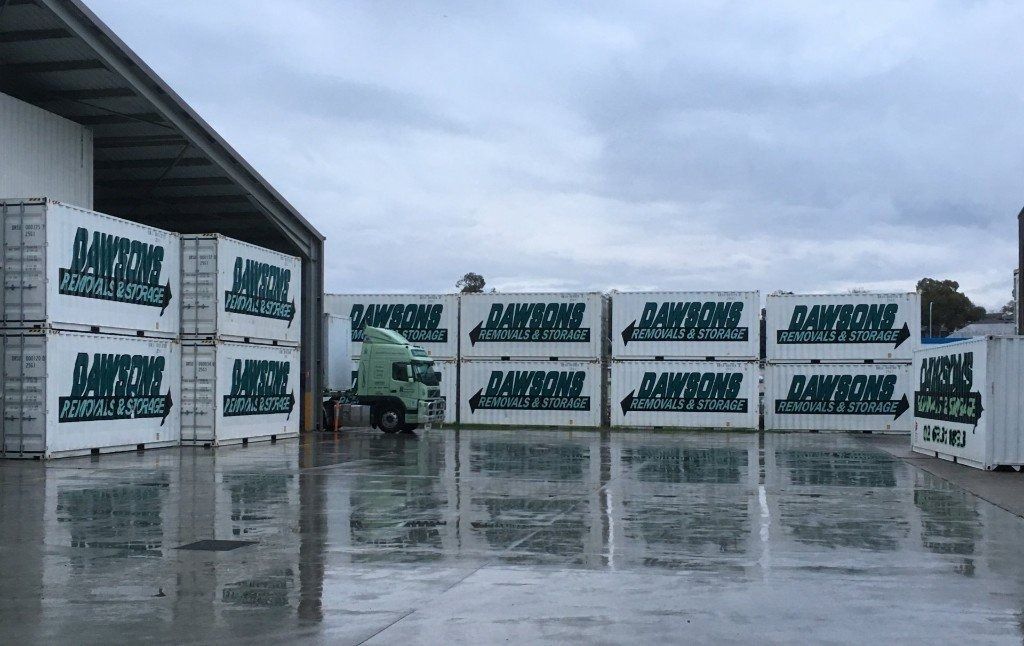 Stacks Of White Shipping Containers With Green Text — Dawson's Removals In Dubbo, NSW