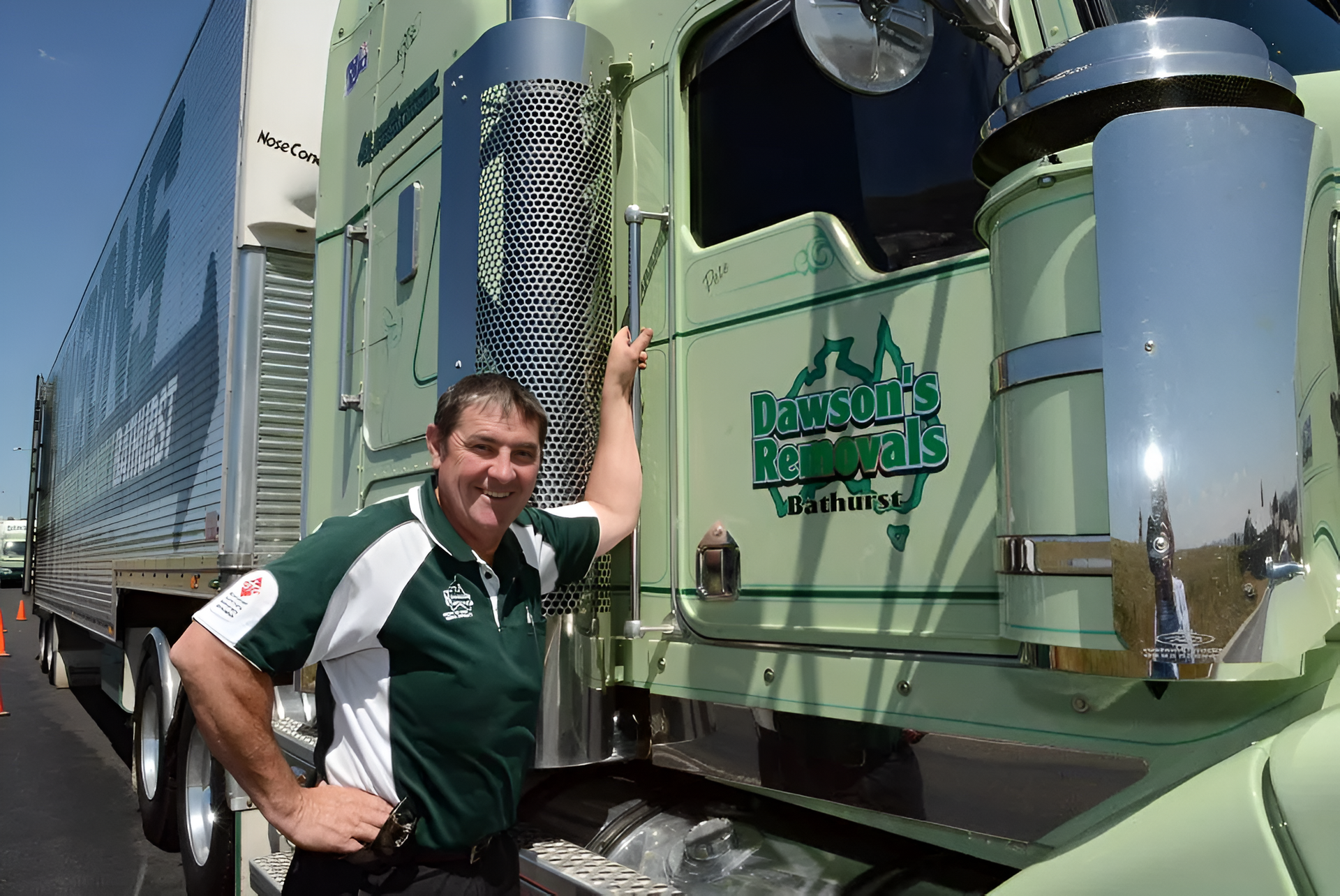 Man in Green Shirt Stands Next to a Mint Green Semi-truck — Dawson's Removals In Kelso, NSW
