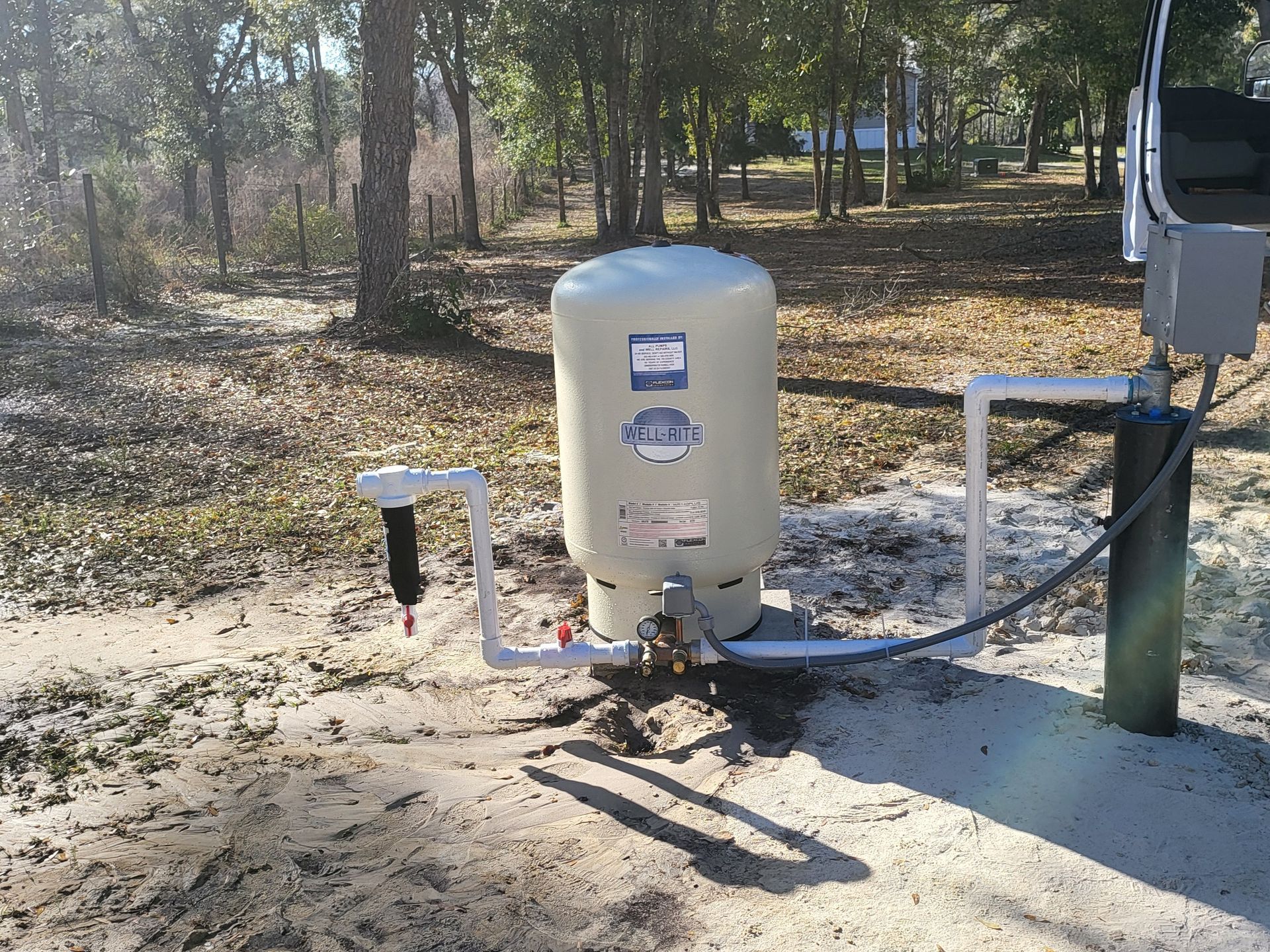 A water pump is connected to a blue pipe in the ground.