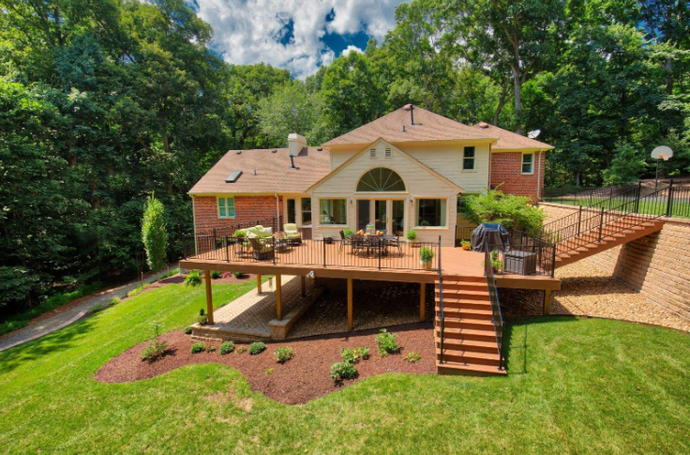 “Large custom wood deck with stairs, railing, and backyard seating area built by deck builders in Allentown, PA”