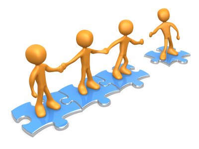 A group of people are standing on puzzle pieces holding hands