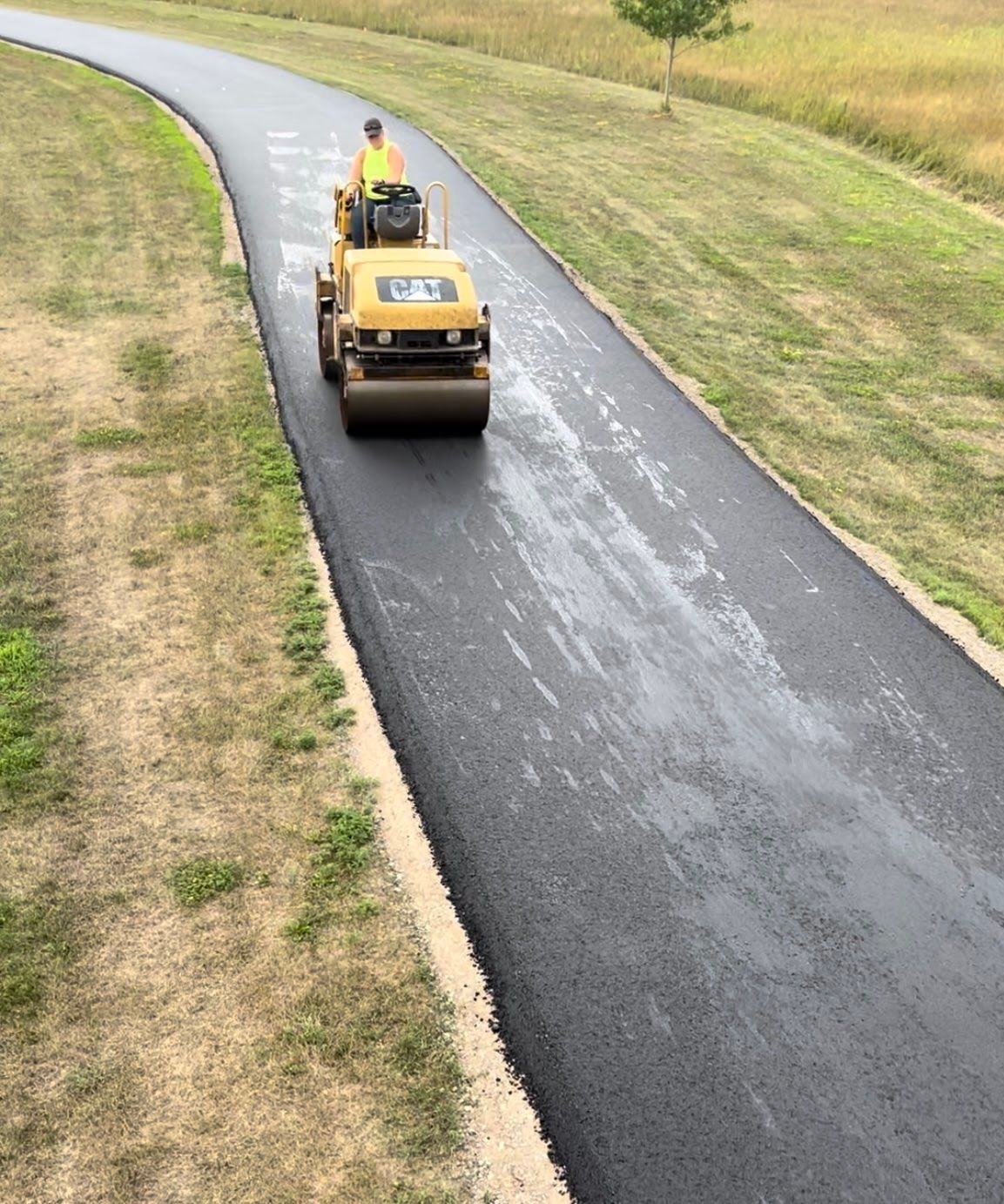 a yellow roller on a asphalt road