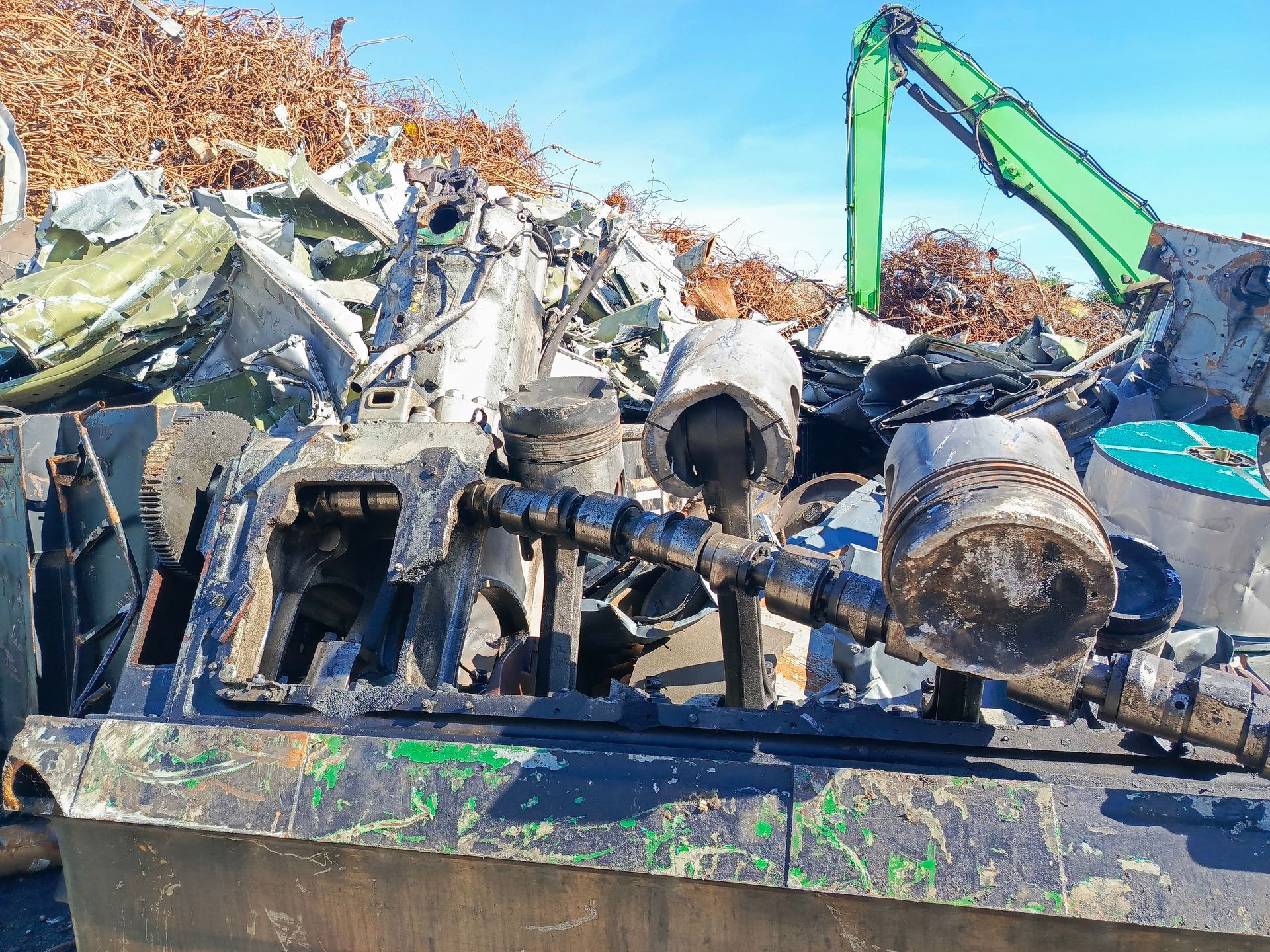 Large broken engine parts in a junkyard with other scrap metal and debris. Large broken engine parts in a junkyard with other scrap metal and debris.