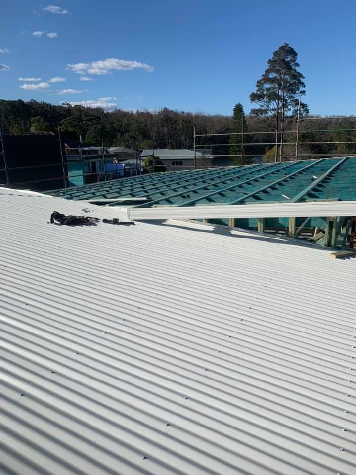 A white roof with a green roof under construction  — Nathan Parnell Roofing In Nowra, NSW