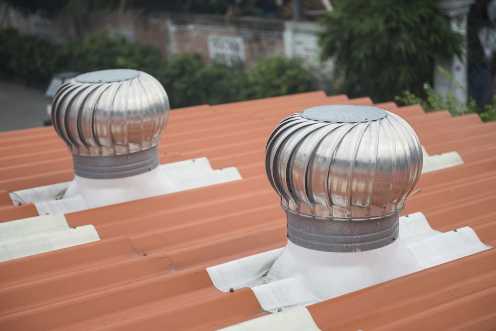 Two Stainless Steel Ventilators Are on the Roof of a Building — Nathan Parnell Roofing In Sussex Inlet, NSW