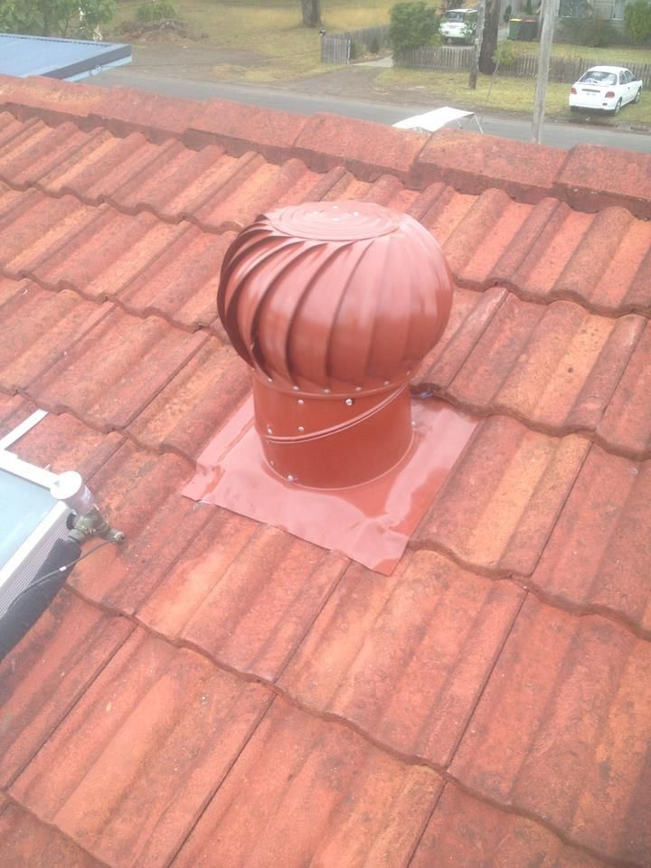 A Red Roof Vent is Sitting on Top of a Tiled Roof — Nathan Parnell Roofing In Vincentia, NSW