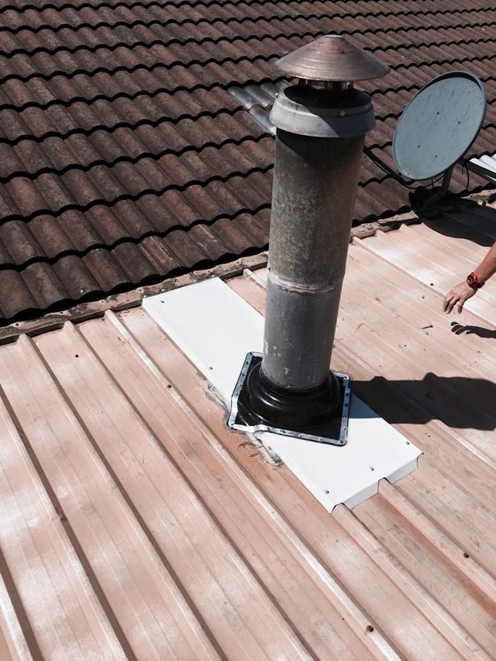 A Roof With a Chimney and a Satellite Dish on It — Nathan Parnell Roofing In Vincentia, NSW