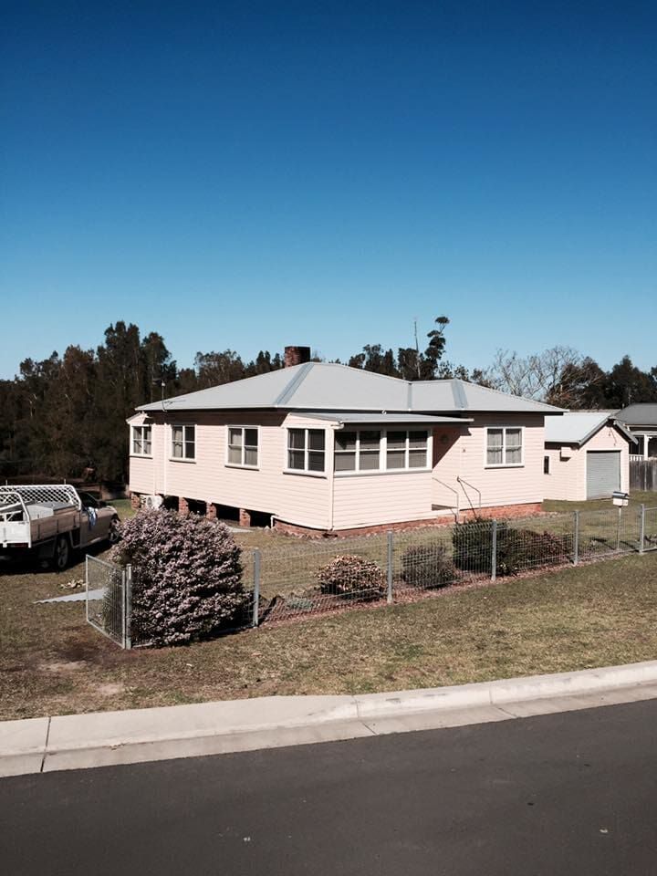 A White House With a Truck Parked in Front of It — Nathan Parnell Roofing In Vincentia, NSW
