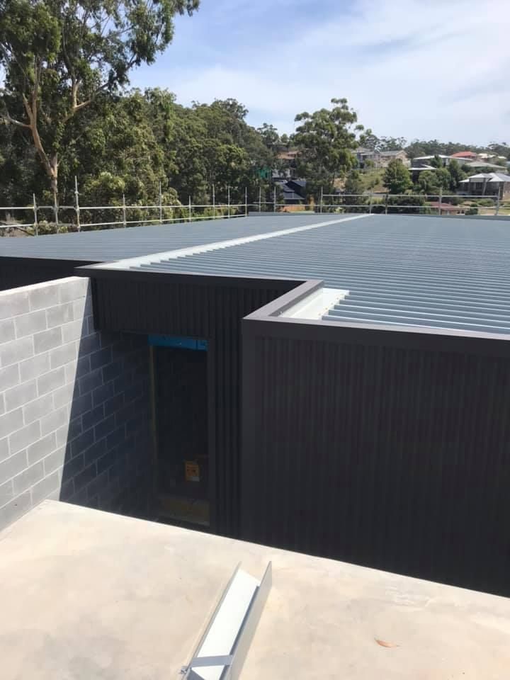 A Building With a Metal Roof — Nathan Parnell Roofing In Sussex Inlet, NSW