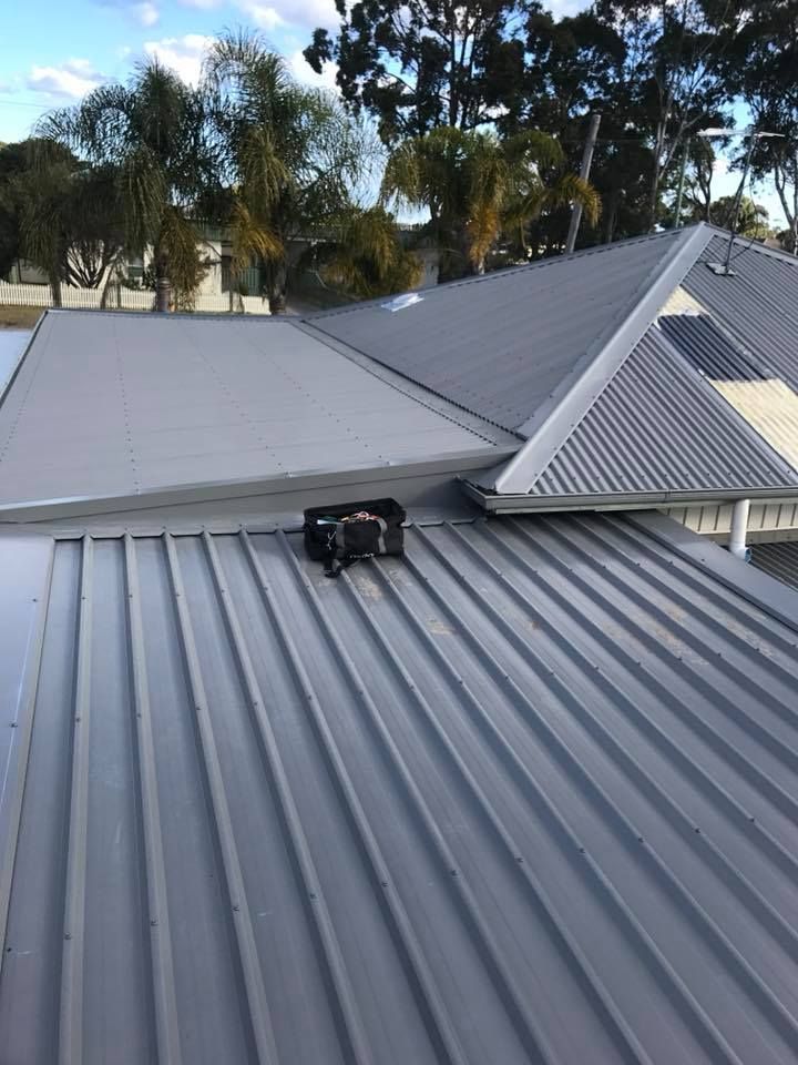 The Roof of a House With a Metal Roof and Trees in the Background — Nathan Parnell Roofing In Vincentia, NSW