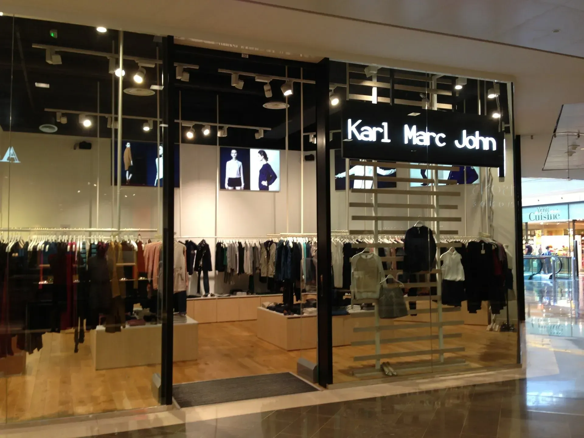 Enseigne lumineuse Karl Marc John au-dessus de l’entrée d’un point de vente du réseau