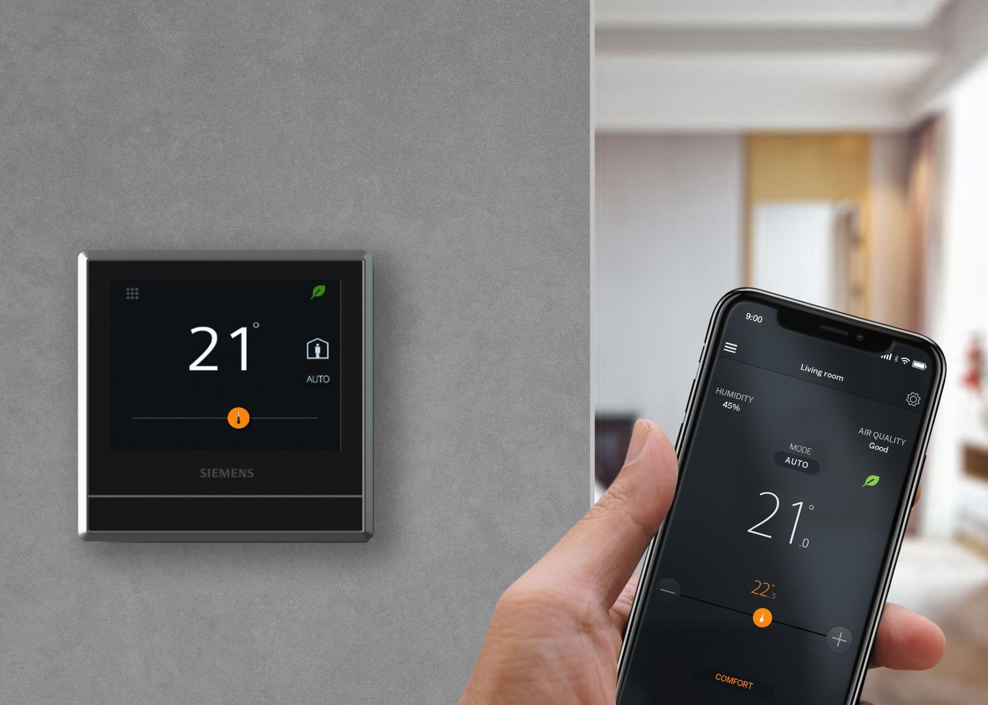 Thermostat on wall with display showing 21 degrees, person holding phone displaying same temperature.