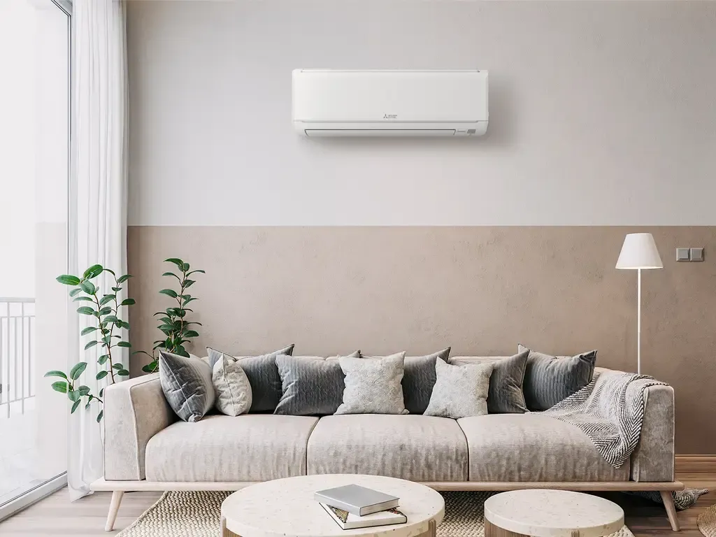 Modern living room with sofa, air conditioner, and round coffee tables.