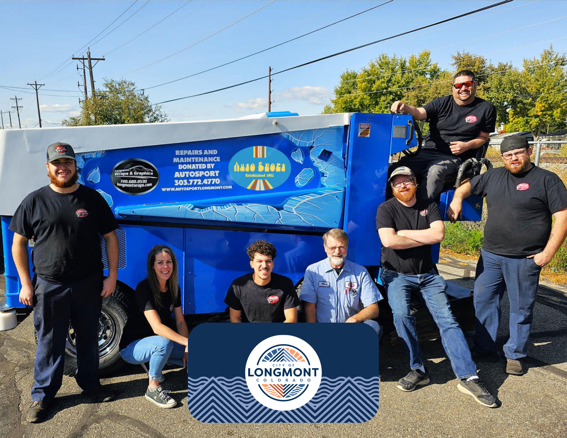 Group of People Posing in Front of a Blue Moving Truck | AutoSport