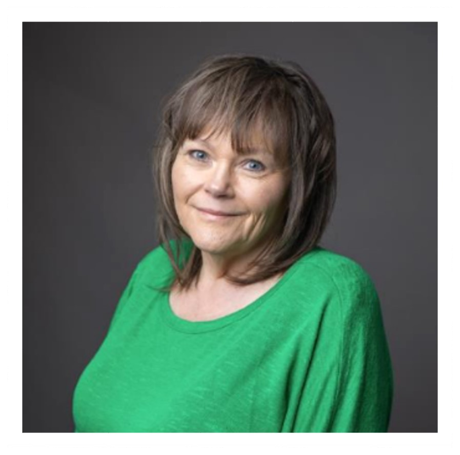 Smiling woman in a bright green top against a gray studio background