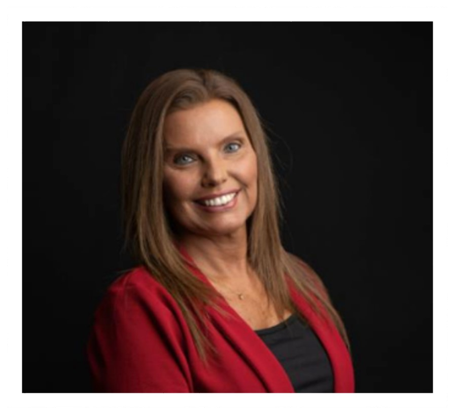 Smiling woman in a red blazer against a black background