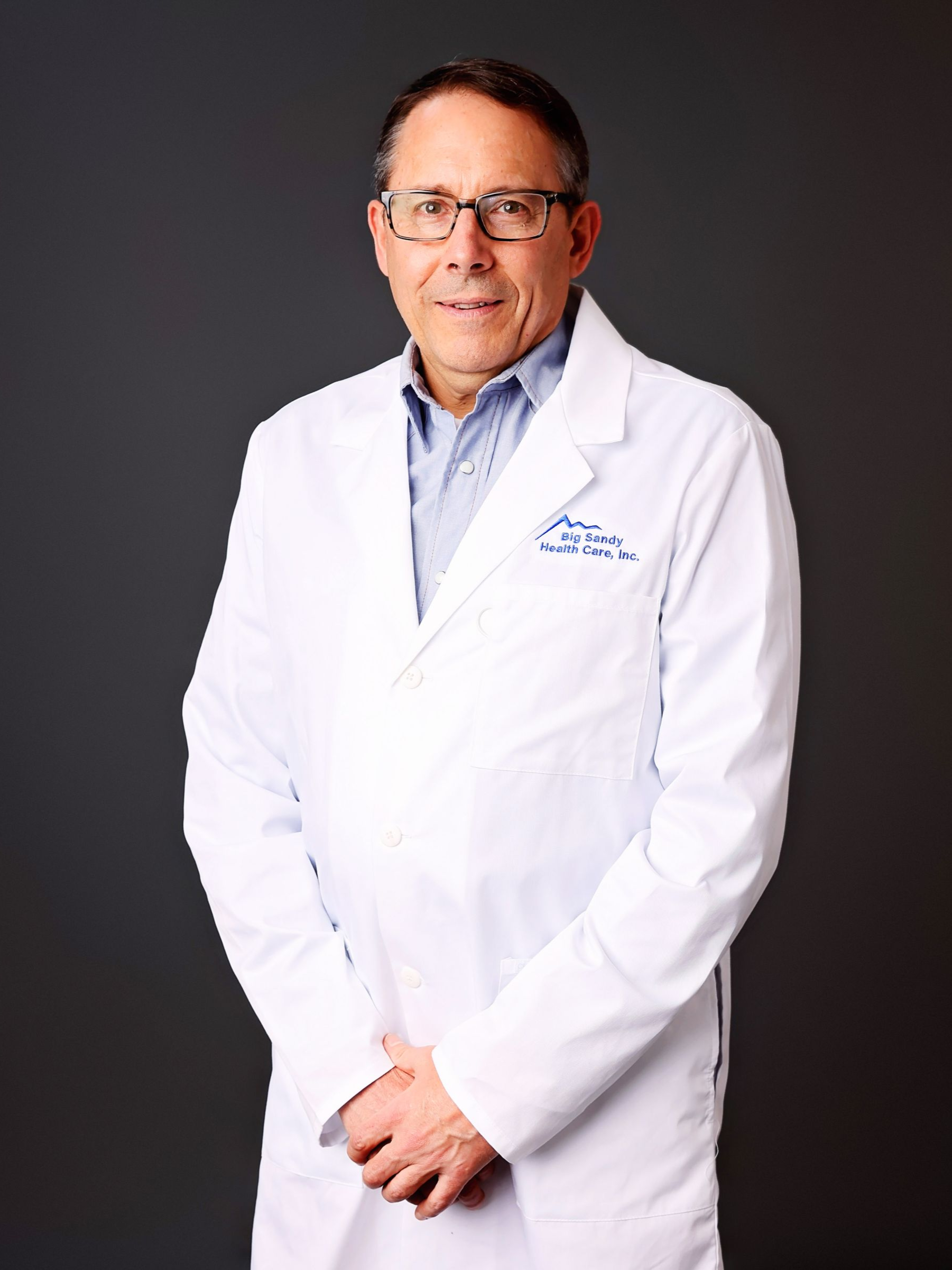 Smiling doctor in a white coat against a black background