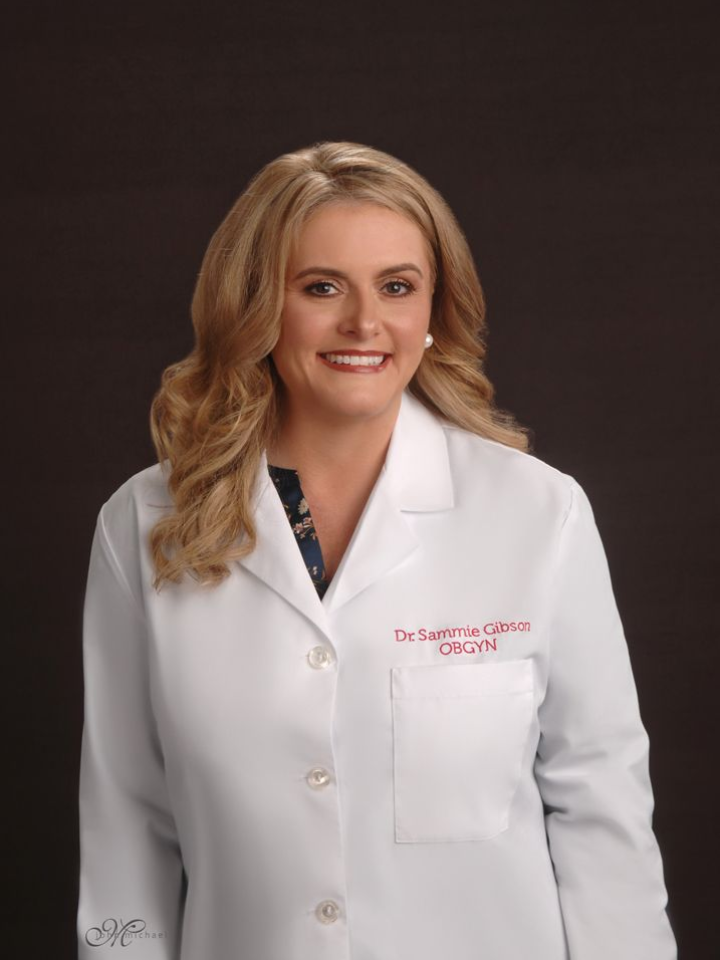 Smiling doctor in a white coat against a dark background
