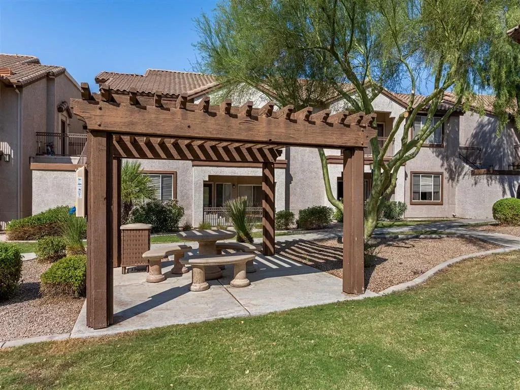 Outdoor seating area with pergola, picnic table, and benches.