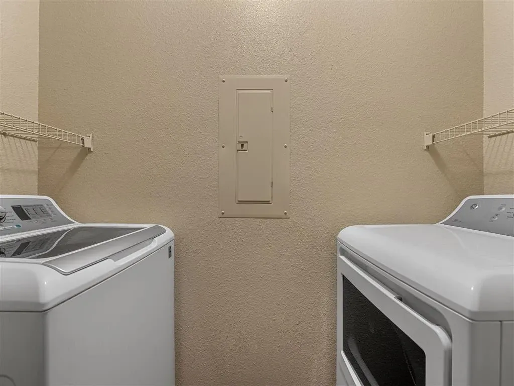 In-unit washer and dryer with overhead shelving.