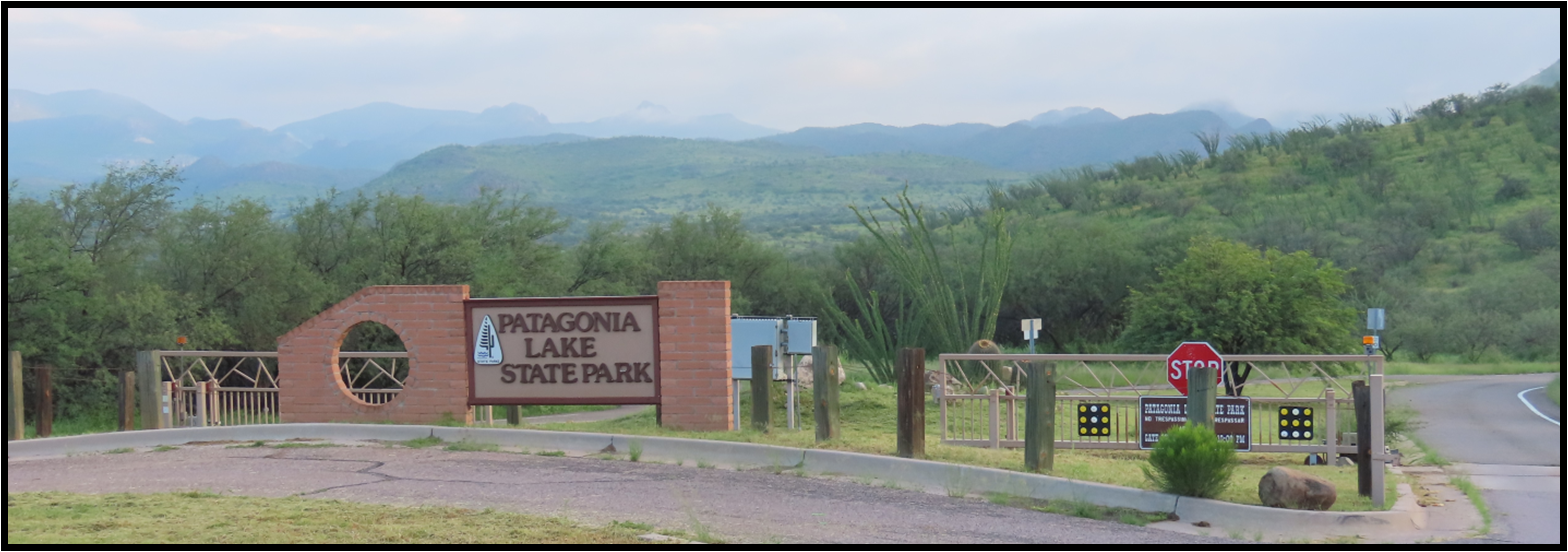 A sign for a state park with mountains in the background