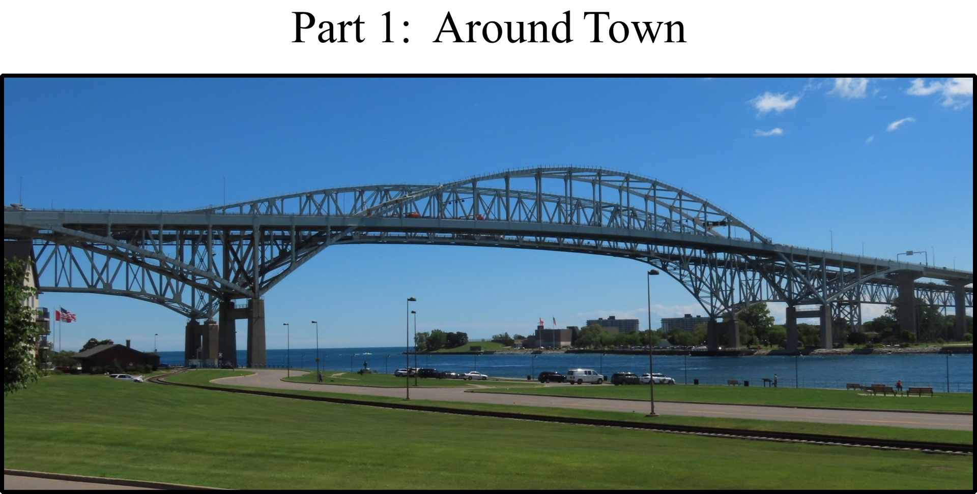 Bridge over water, clear blue sky, green grass in foreground.