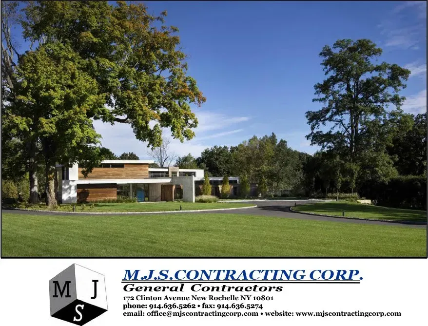 M.J.S. Contracting Corp. office building with green lawn, trees, and company logo banner