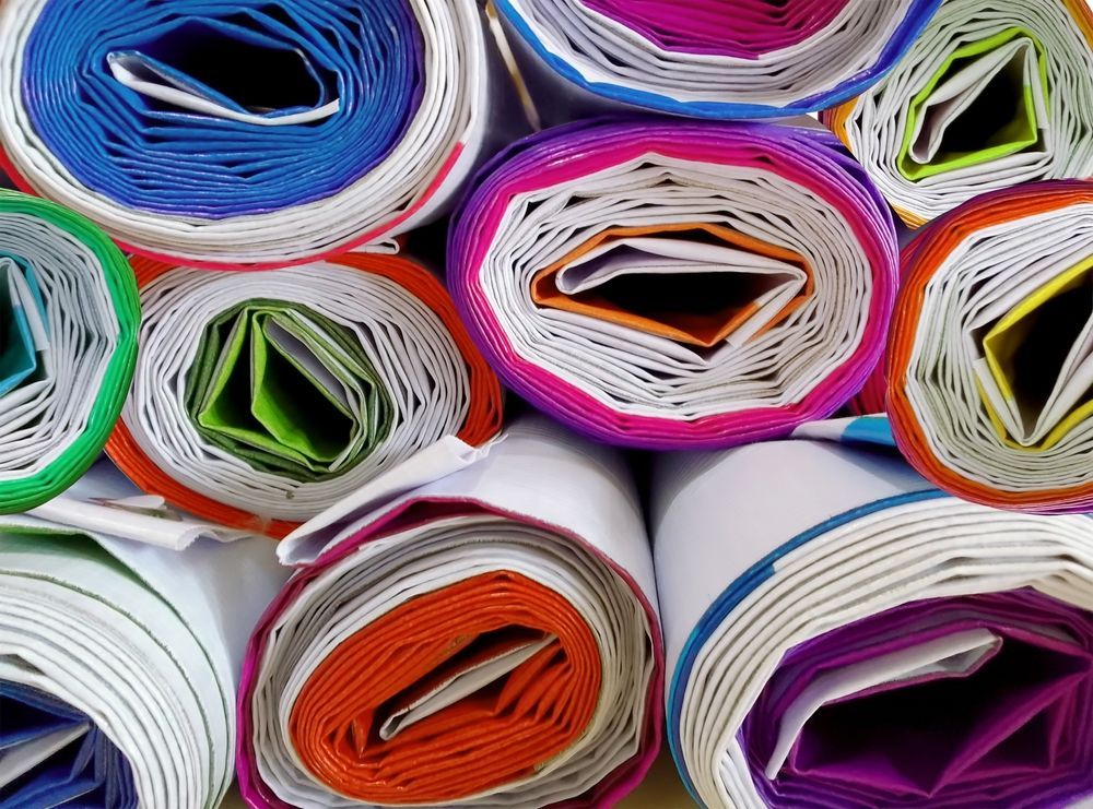 Rolled stacks of colorful paper arranged in a tight, abstract pattern