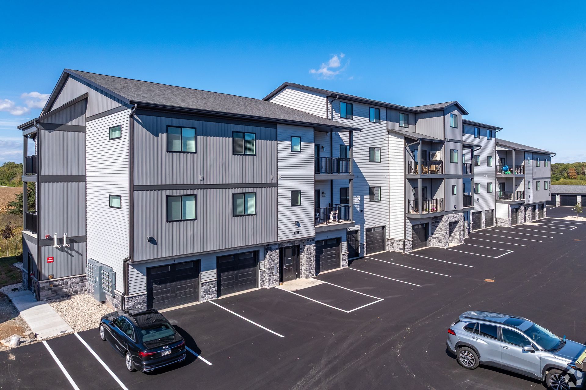 Modern apartment buildings with parking lot under a clear blue sky