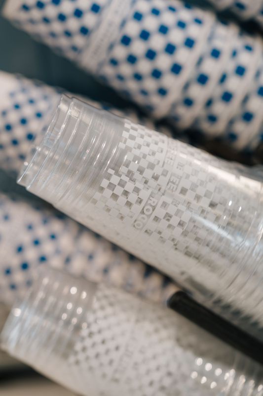 Close-up of clear woven hose or tubing with blue-dotted fabric in the background